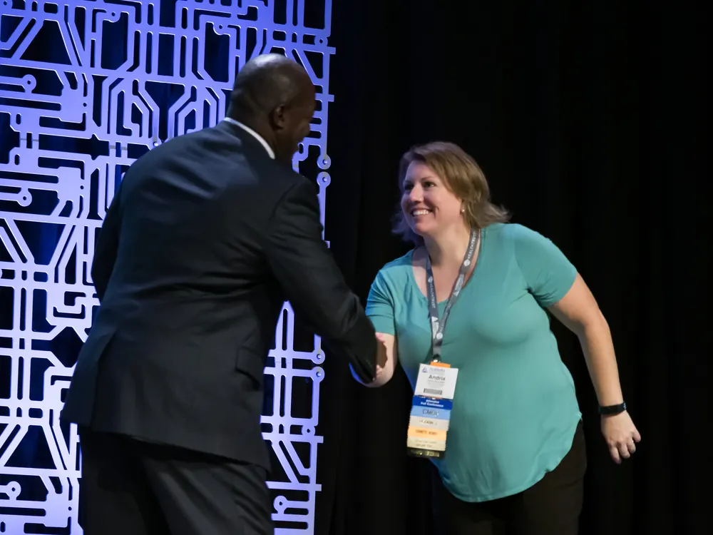 Devon Harris shaking hands with an attendee after his keynote
