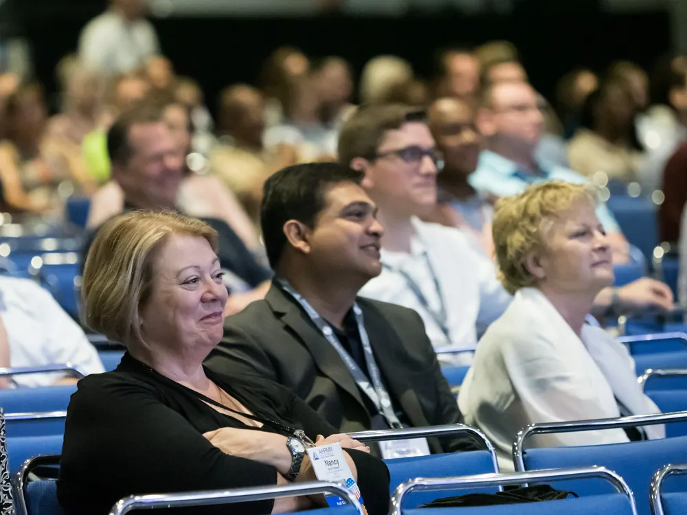 Diverse conference audience laughing during diversity speaker Devon Harris's keynote