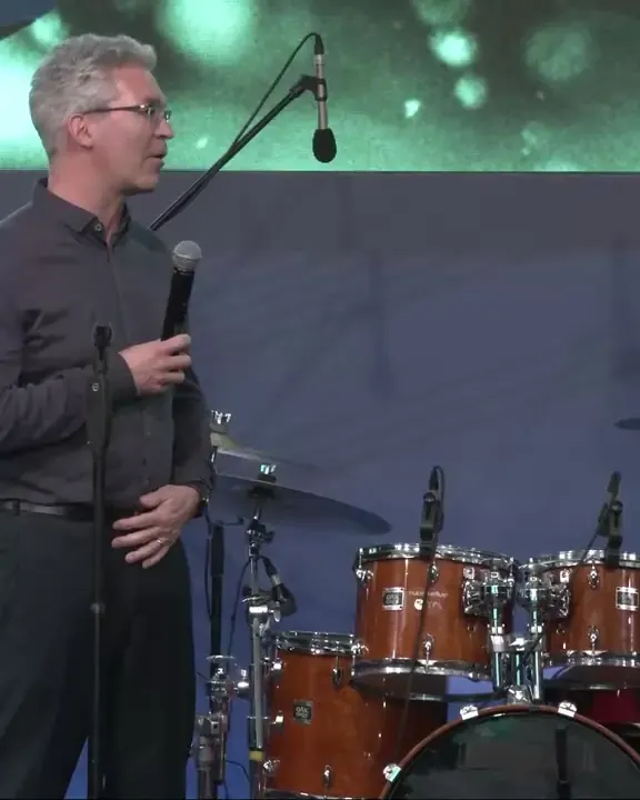 Senior leader thanking Devon Harris on stage at an oncology leadership meeting
